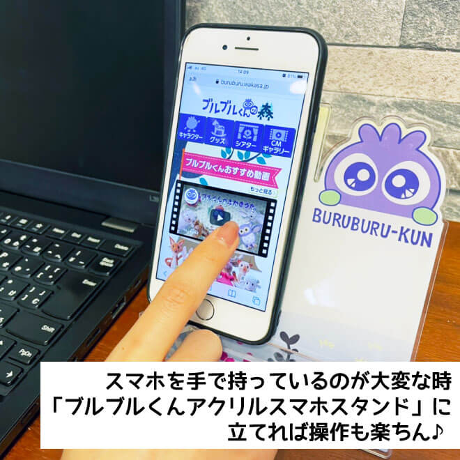 仕事をしながらでもスマホスタンドがあれば、片手で簡単に操作できる。パソコンの横にあるブルブルくんのスマホスタンドの画像
