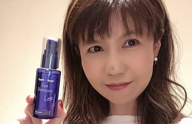若々しく笑顔が素敵な女性がアイシャンプーのボトルを持っている